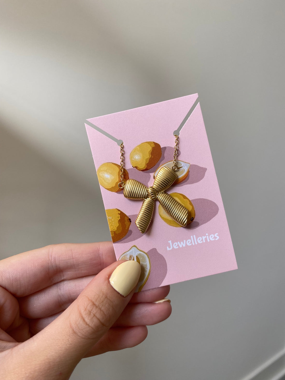 Strikjes ketting in het goud om sieradenkaartje