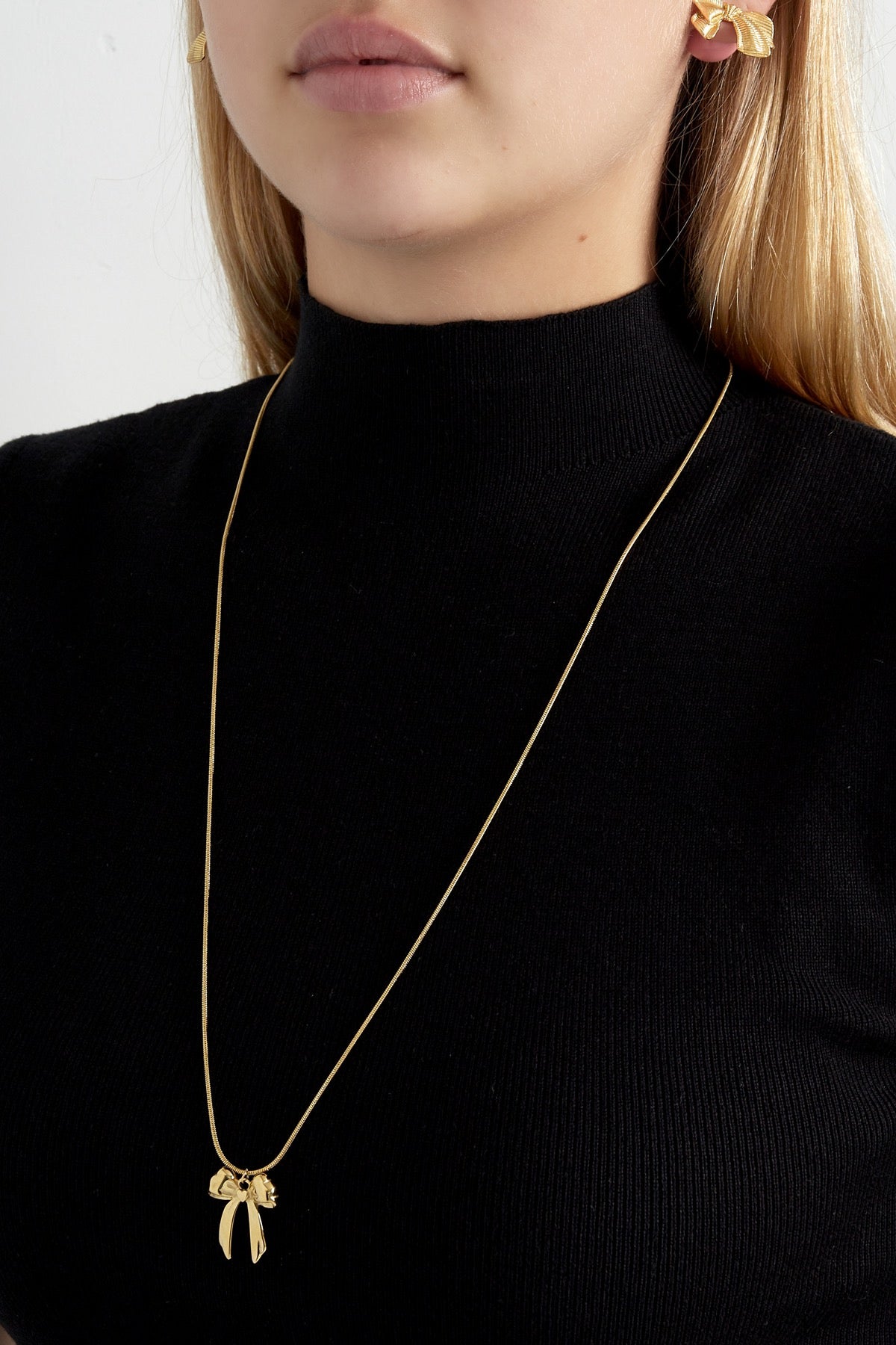 Lange ketting met strik hanger goud om hals