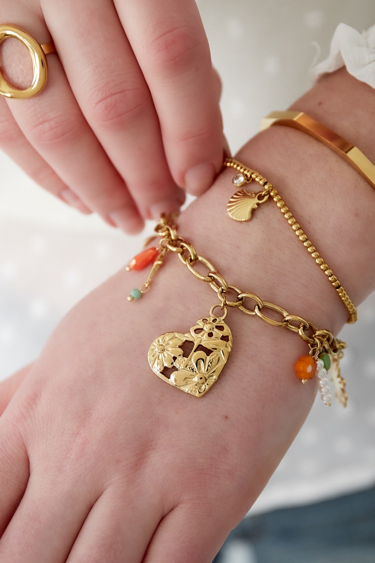 Bedelarmband met hartjes, bloem en kralen goud