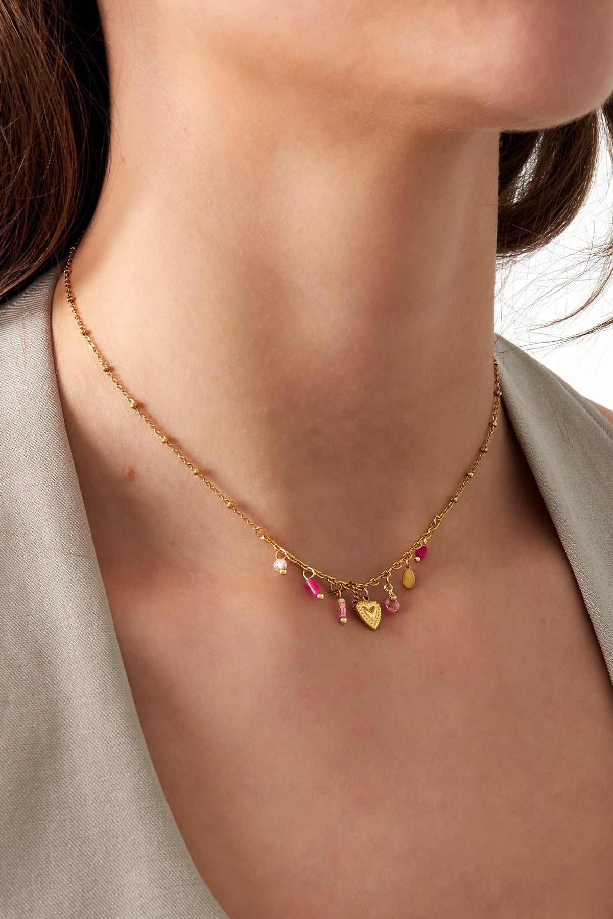 Minimalistische subtiele ketting met roze bedels en hartjes goud