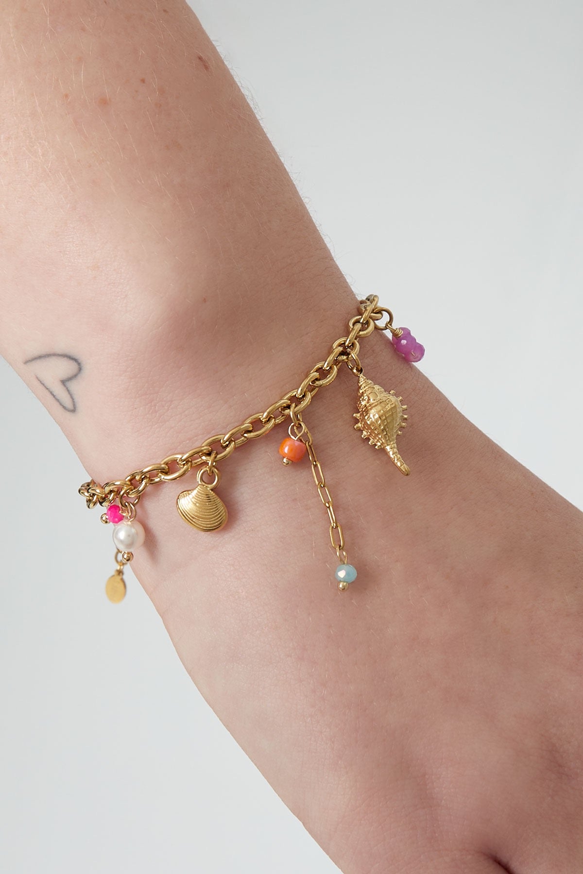 Bedelarmband kleur en schelpen in het goud om pols