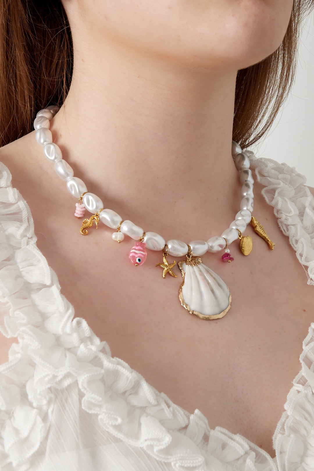 Grote bedelketting met parels en zomerse bedels in het goud
