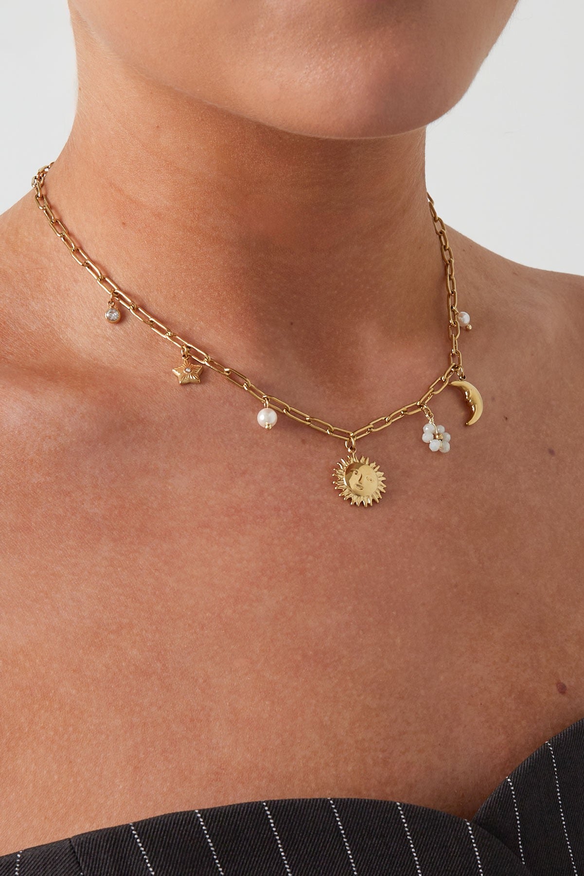Schakelketting met minimalistische bedels van zon, ster, parel en maan goud