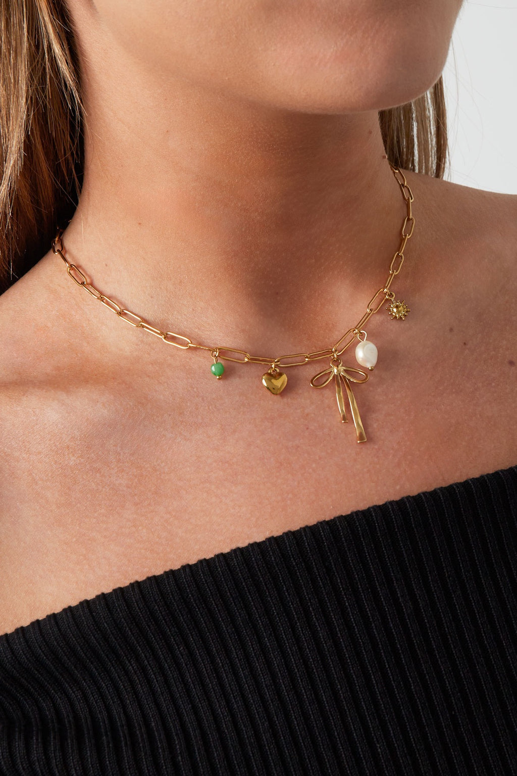 Schakelketting met bedels van hart, strik en parel in het goud om hals