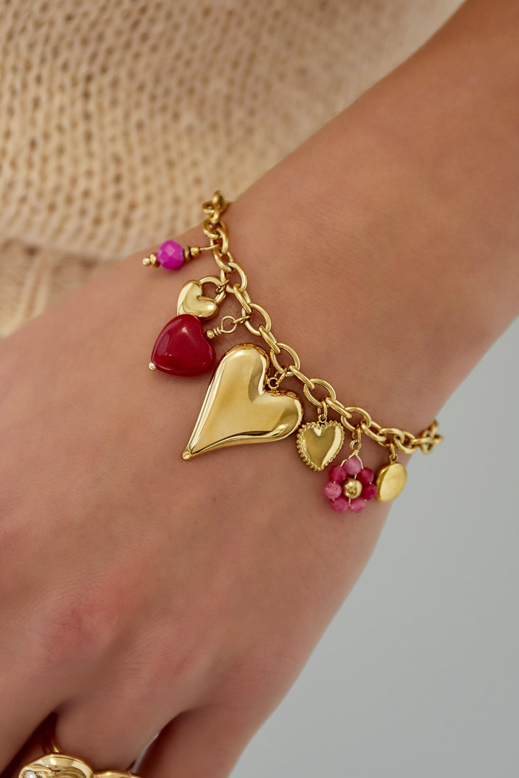 Opvallende bedelarmband in goud met harten en gekleurde details