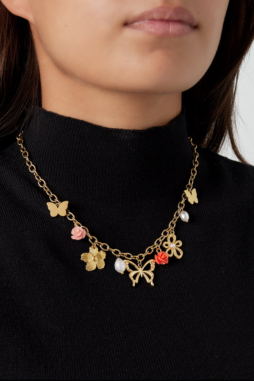 Cheerful charms ketting met bedels van vlinder, bloemen en parels in het goud op model