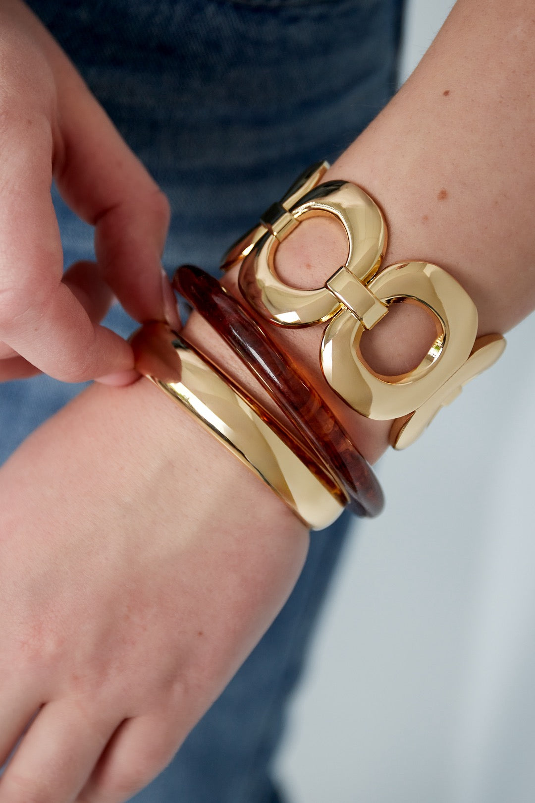 Statement bangle armband in het goud om pols bij model