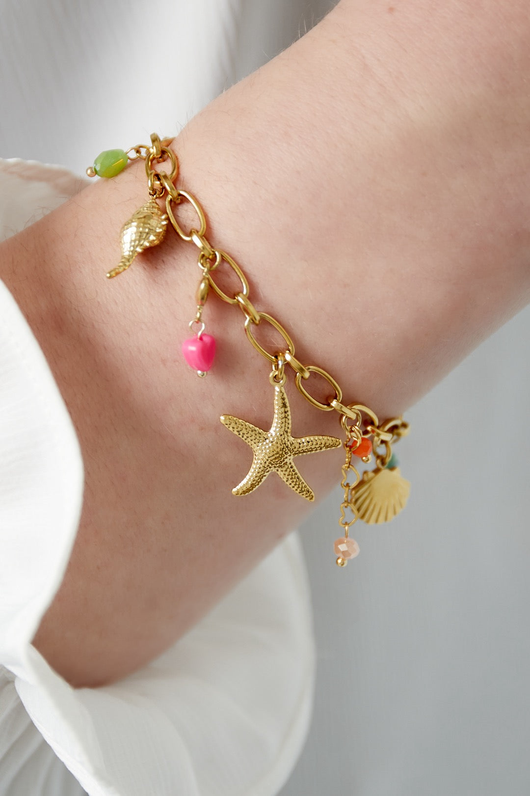 Zomerse bedelarmband met kleurrijke hangers in het goud