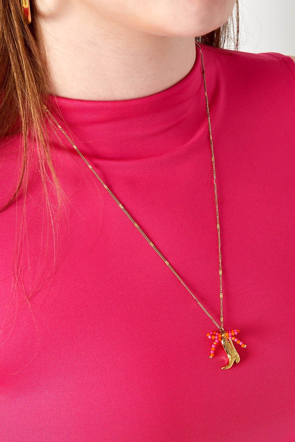 Ketting met hanger van cowboy laars en strikje goud