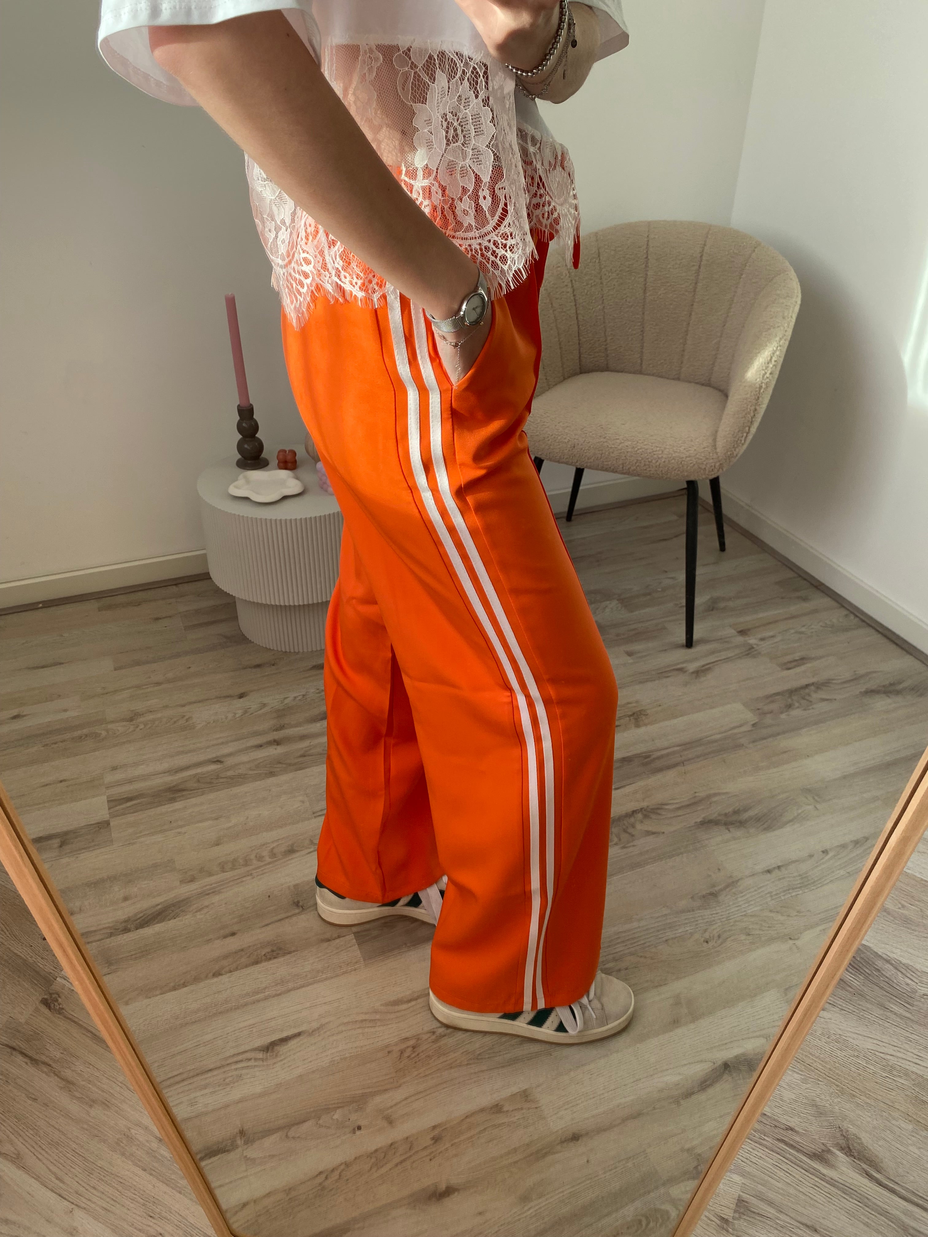 Pantalon broek in oranje kleur met witte streep aan de zijkant