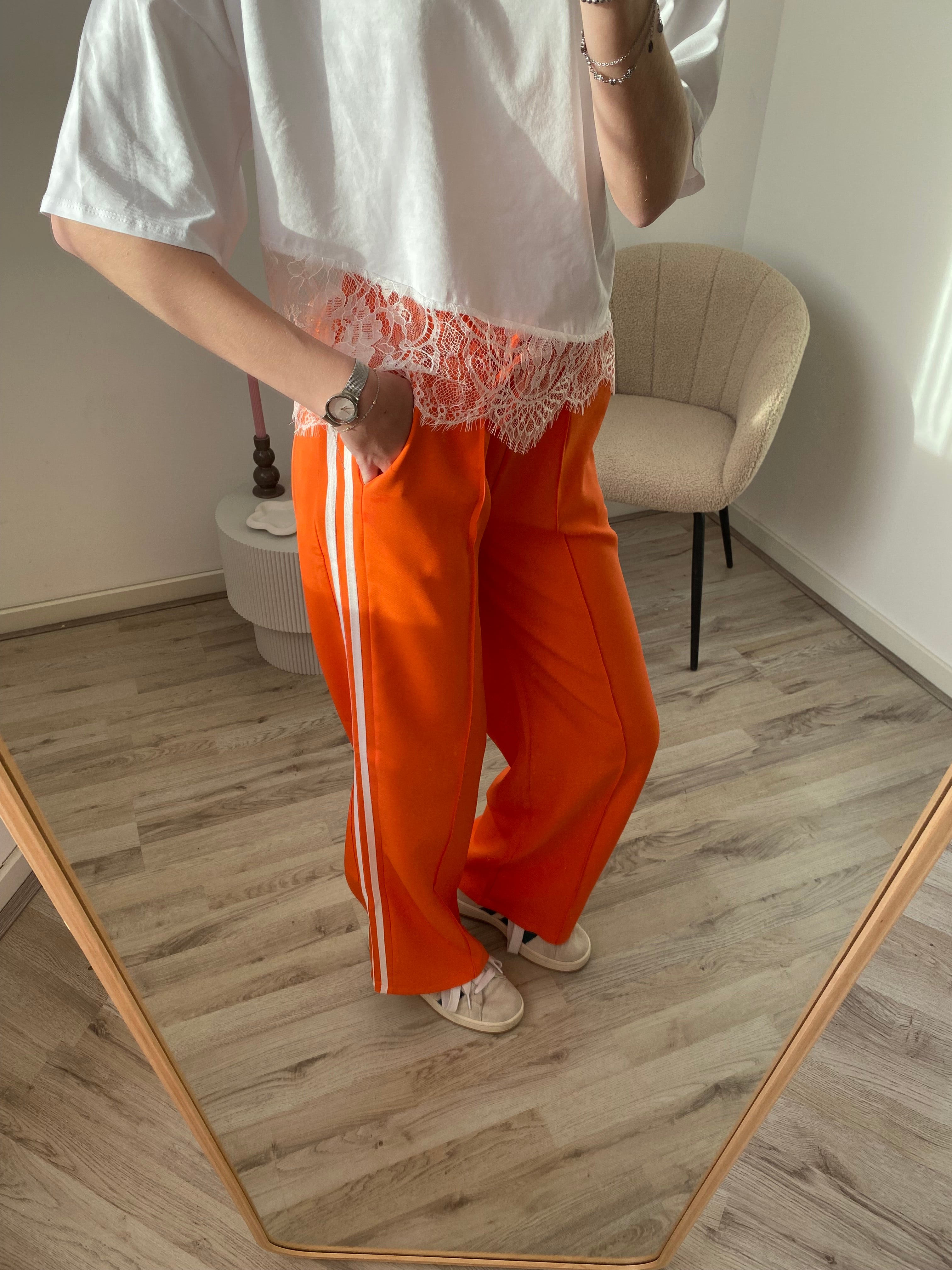 Pantalon broek in oranje kleur met witte streep aan de zijkant