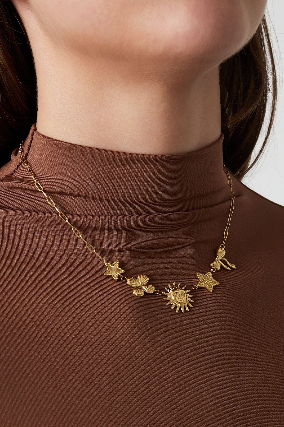 Statement ketting met verschillende figuurtjes van bloem, zon, ster en strik in het goud