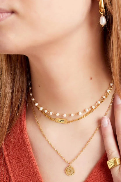 Ketting subtiel met schakels en love bedel in het goud