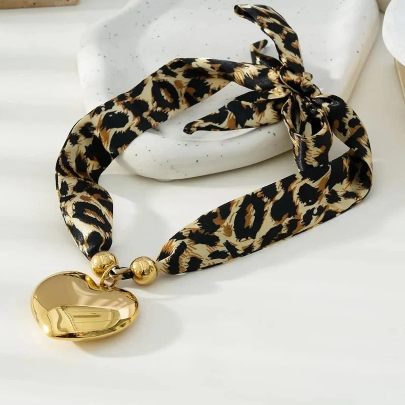 Ketting van panterprint stof met hartjes hanger in het goud