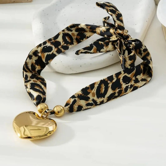 Ketting van panterprint stof met hartjes hanger in het goud