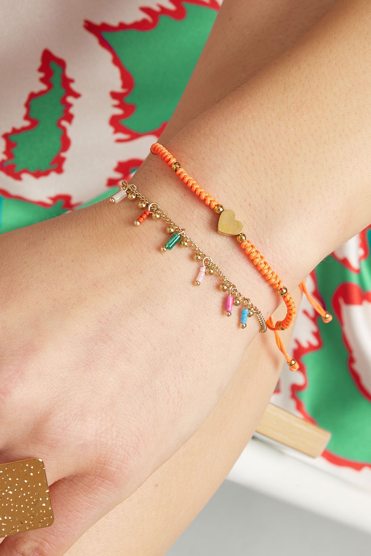 Subtiele goudkleurige armband met hangertjes in kleur