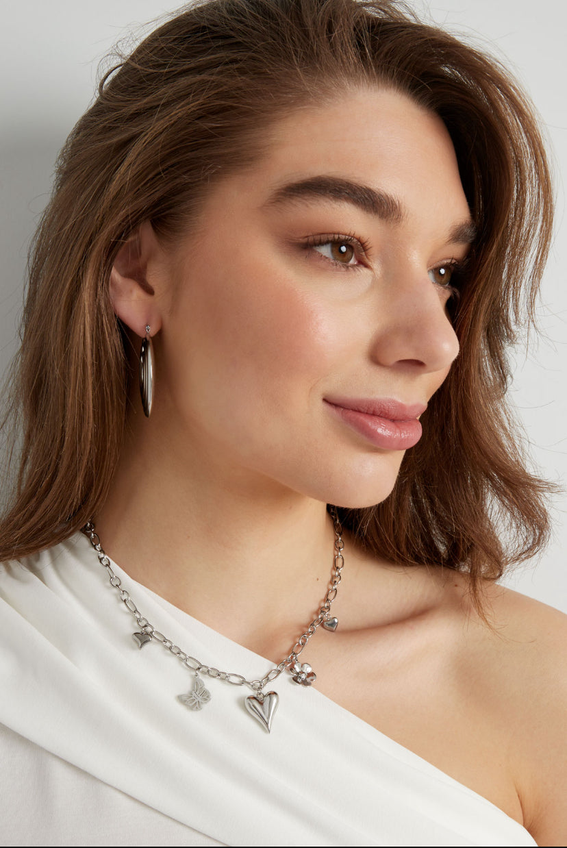 Opvallende bedelketting zilverkleurig hartjes, vlinder en bloem waterproof