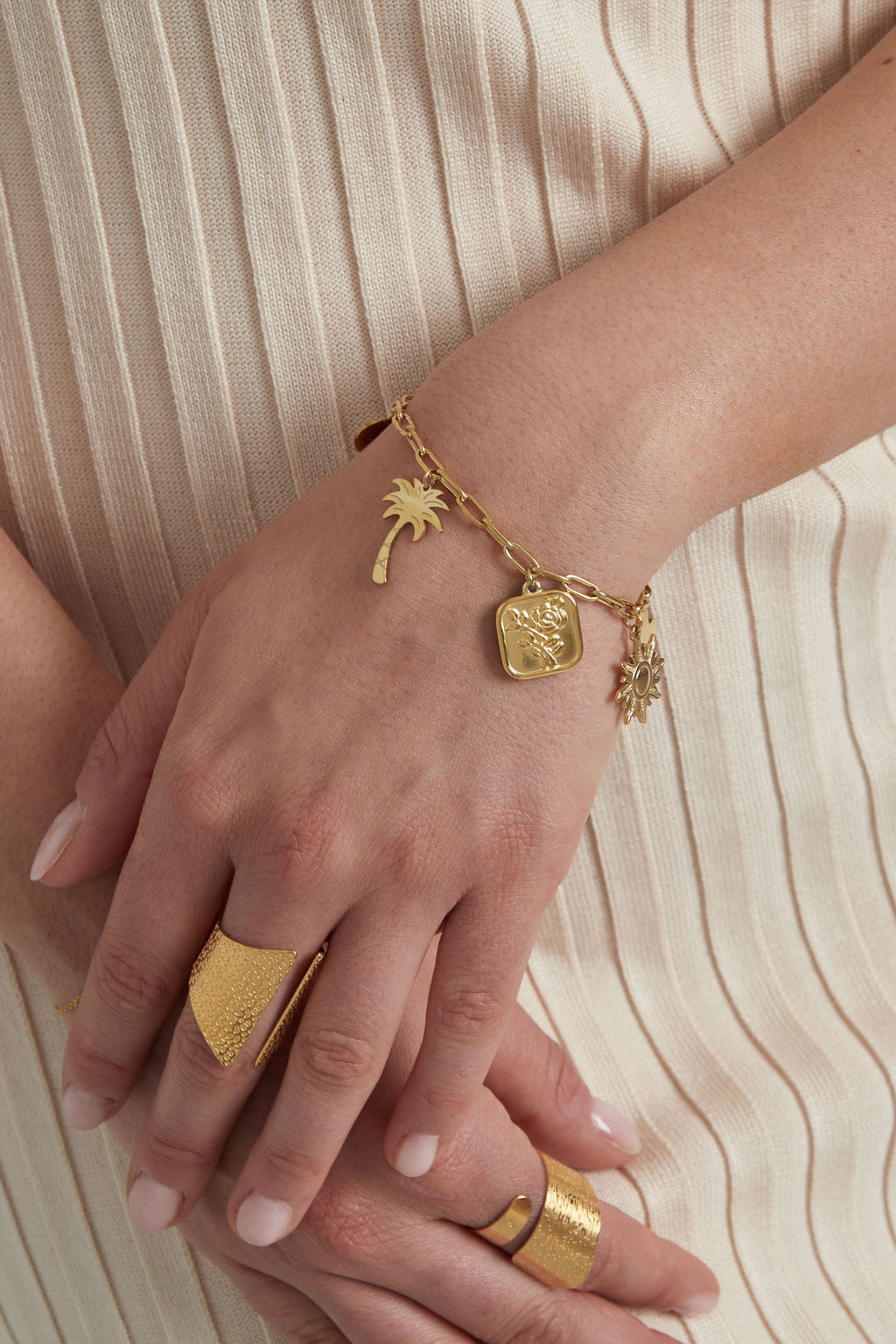 Bedelarmband goudkleurig om pols met palmbomen, zonnetjes en hartjes