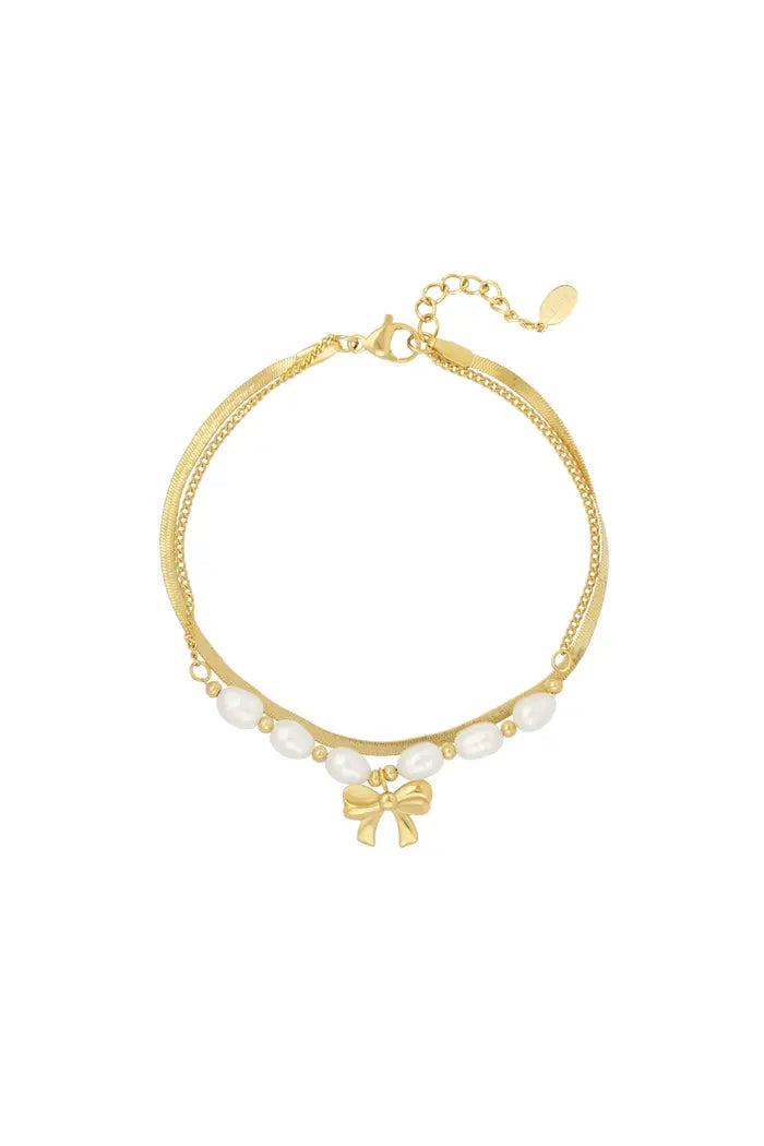 Sierlijke armband platte schakel, parels en strikje goudkleurig