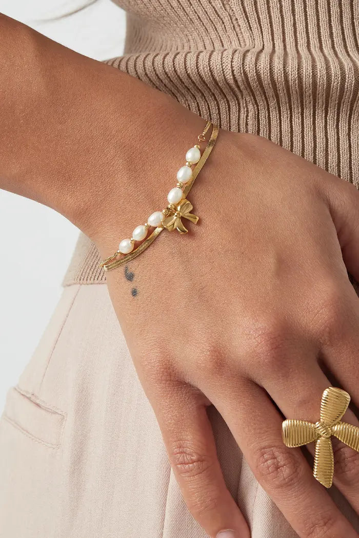 Subtiele armband goudkleurig strik en parels