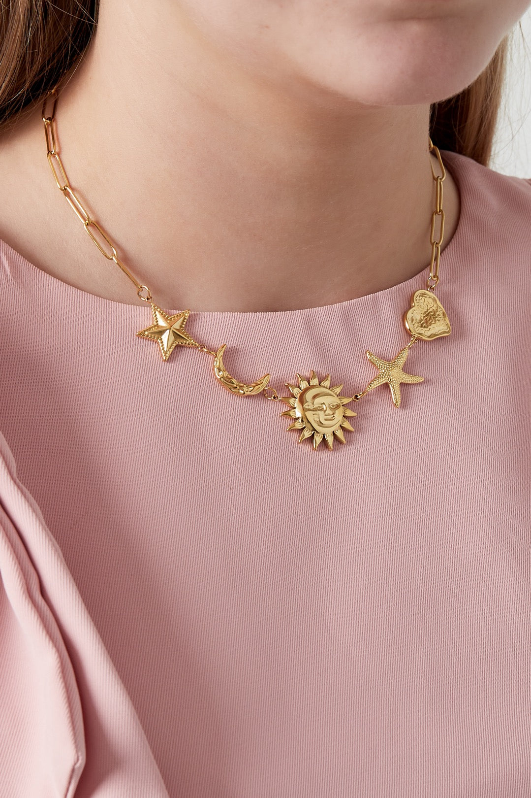 Ketting met schakels en bedels van sterren, maan, zon en hart in het goud