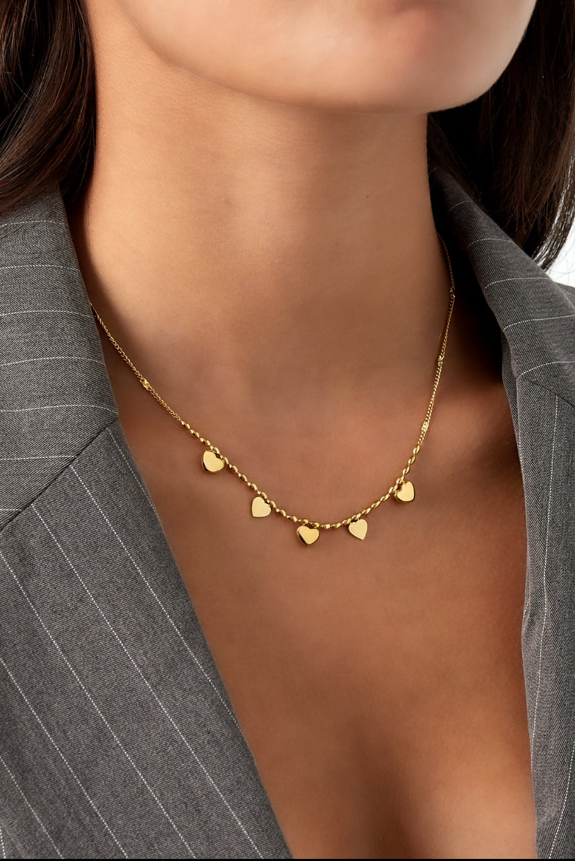 Subtiele hartjes bedelketting in het goud op model