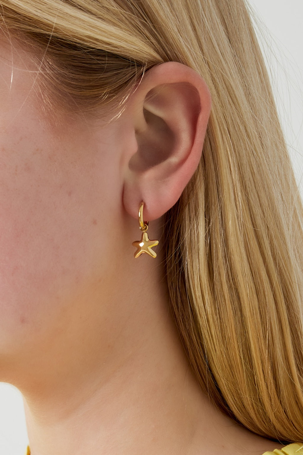 Kleine sterretjes oorbellen goud in oor